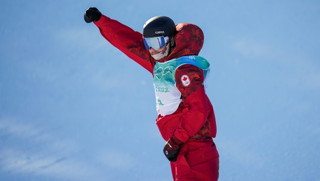 Le planchiste canadien Darcy Sharpe lève le poing droit dans les airs après sa performance au big air en snowboard masculin à Beijing 2022.
