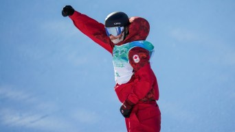 Le planchiste canadien Darcy Sharpe lève le poing droit dans les airs après sa performance au big air en snowboard masculin à Beijing 2022.