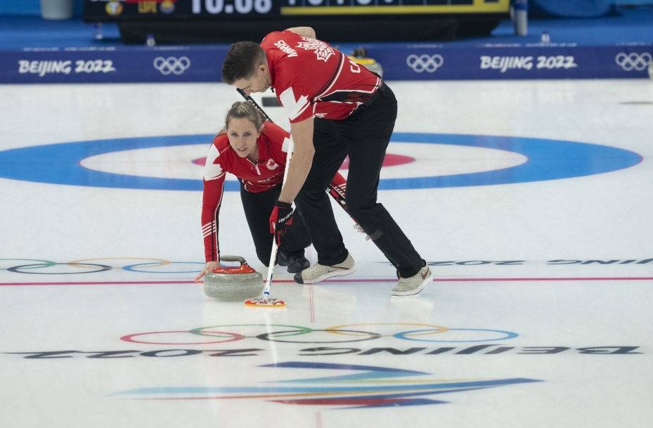 La Canadienne Rachel Homan lance une pierre pendant que John Morris balaie durant la ronde préliminaire contre la Tchéquie en curling double mixte à Beijing 2022.