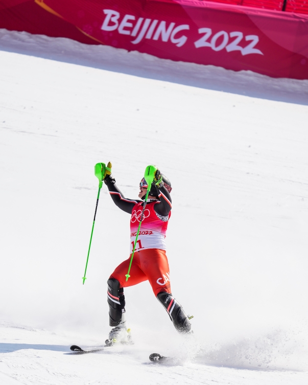 Le skieur alpin d'Équipe Canada Jack Crawford lève les bras dans les airs après sa course de slalom de l'épreuve de combiné alpin à Beijing 2022.