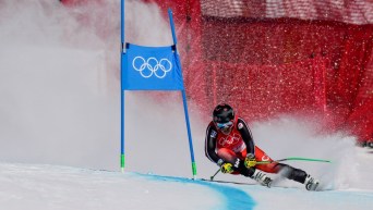 Le skieur alpin canadien Jack Crawford dépasse une porte lors d'un virage au super-G masculin aux Jeux olympiques de Beijing 2022.