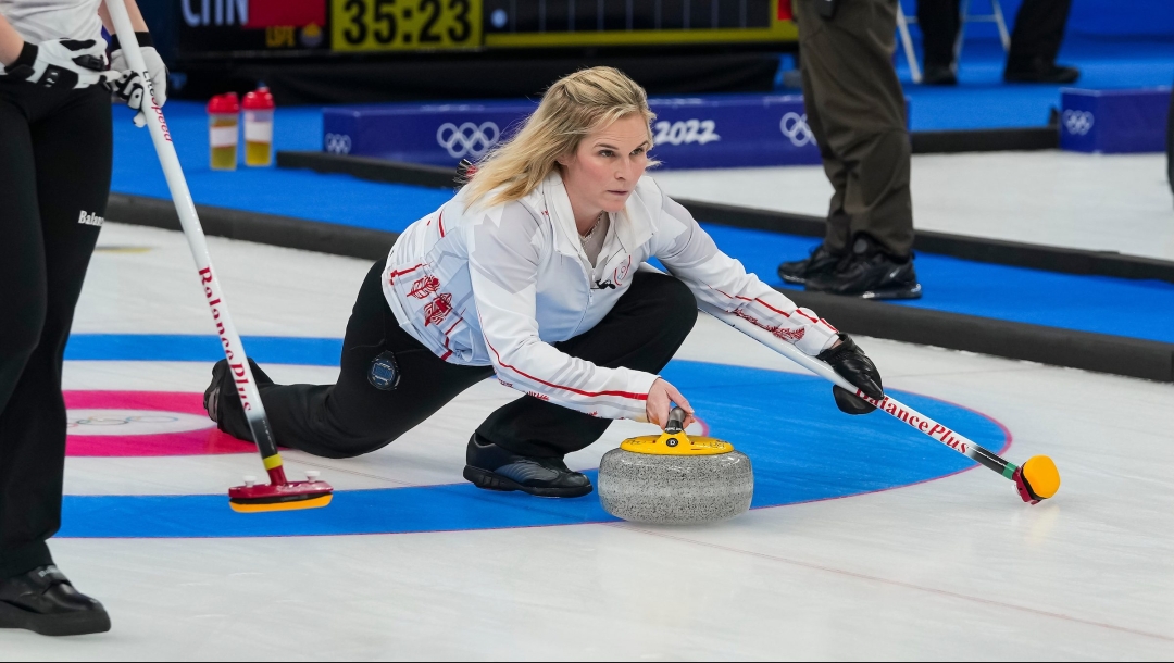 Jennifer Jones, un genoux sur la glace, tend le bras devant elle pour lancer une pierre lors du match de curling contre la Suisse à Beijing 2022