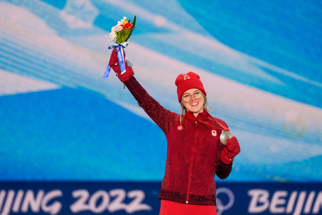 Cassie Sharpe sur le podium sa médaille dans la main gauche et des fleurs dans la main droite. 