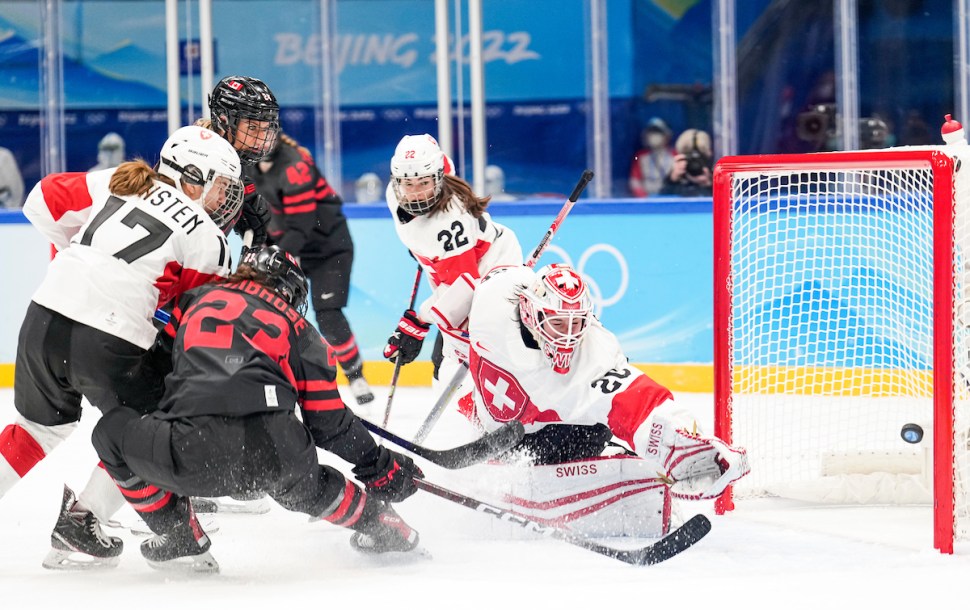 Erin Ambrose (23) d'Équipe Canada compte un but contre Andrea Braendli (20) de la Suisse dans la victoire du Canada 12 à 1 lors du tournoi préliminaire de hockey féminin des Jeux olympiques de Beijing 2022.