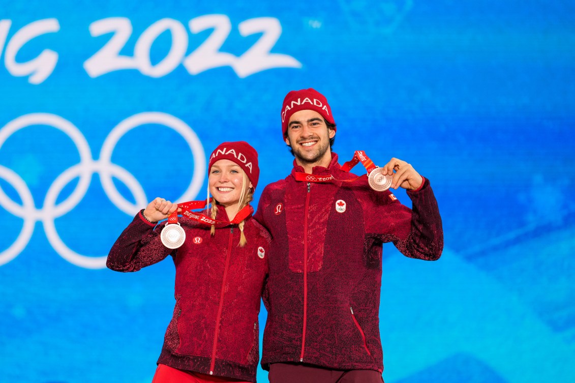 Meryeta O'Dine et Eliot Grondin sur le podium avec leur médaille de bronze au cou.