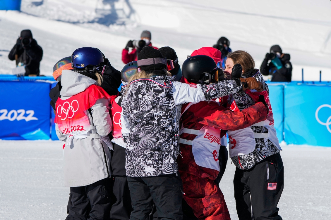 La planchiste d'Équipe Canada Laurie Blouin serre un groupe de compétitrices dans ses bras après avoir participé à l'épreuve féminine de snowboard.