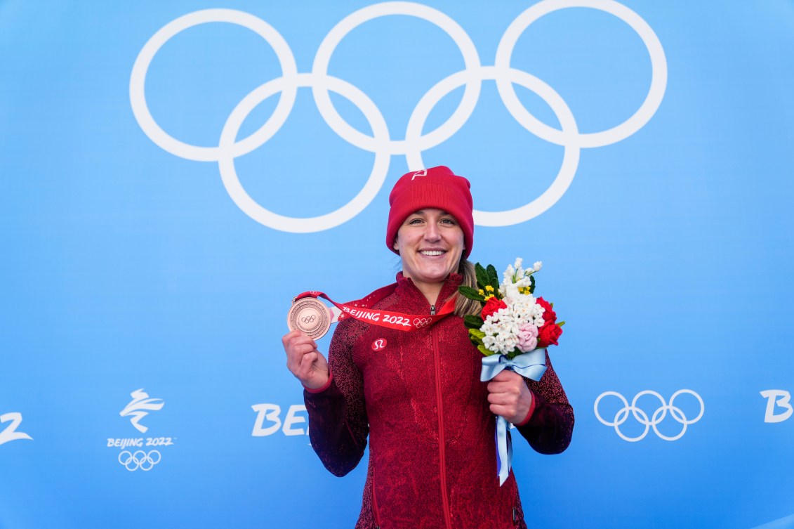 Christine de Bruin sur le podium avec la médaille de bronze autour du cou et les fleurs dans la main gauche.