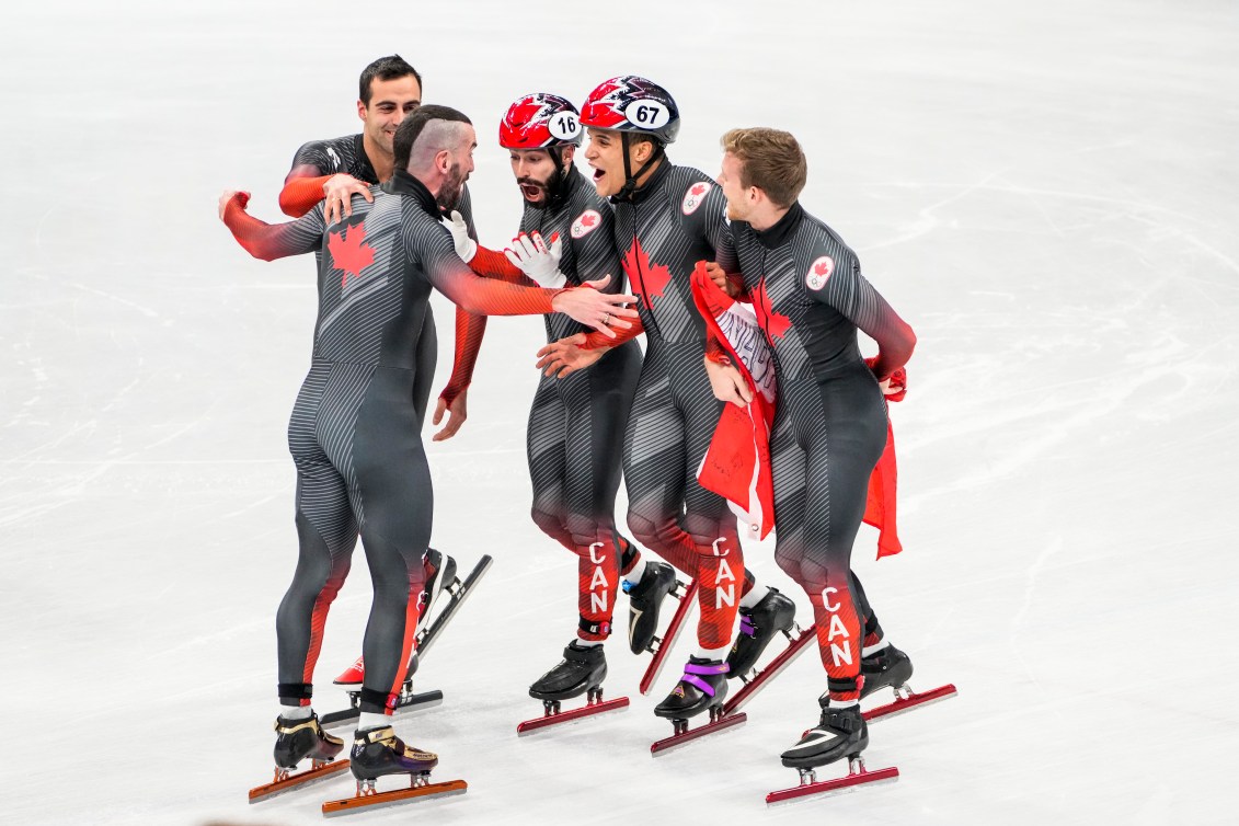 Les patineurs de vitesses réagissent en se serrant les épaules sur la patinoire. 