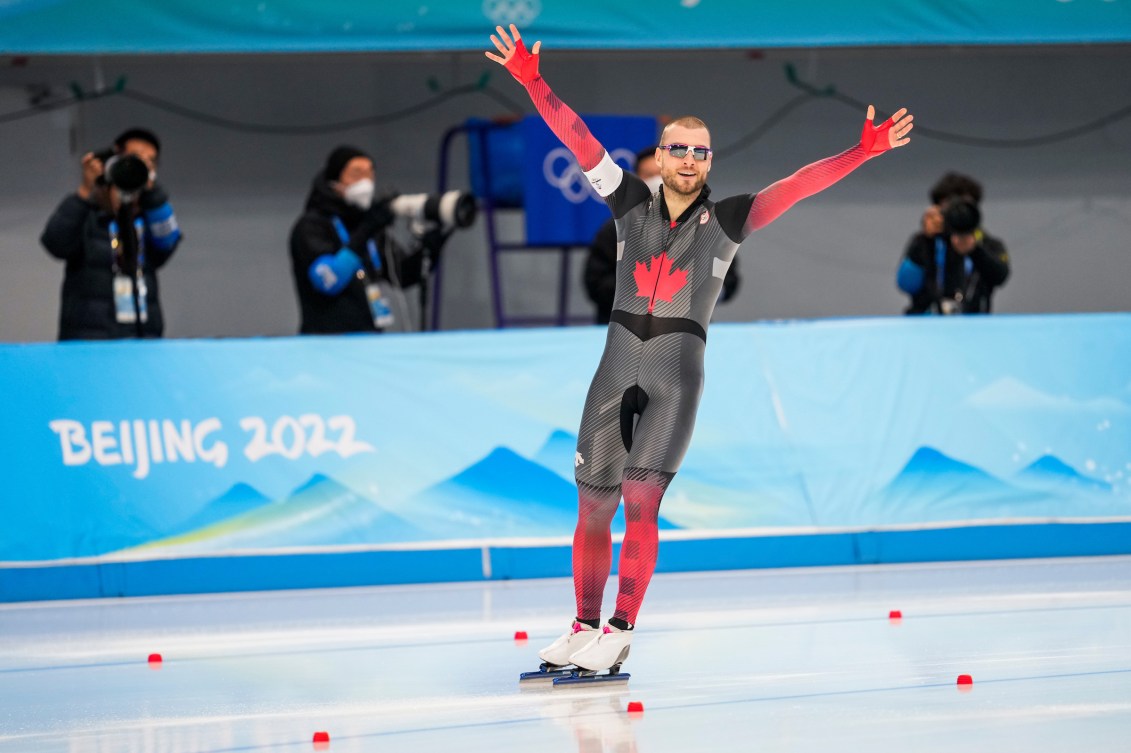 Laurent Dubreuil lève les bras dans les airs sur la patinoire. 