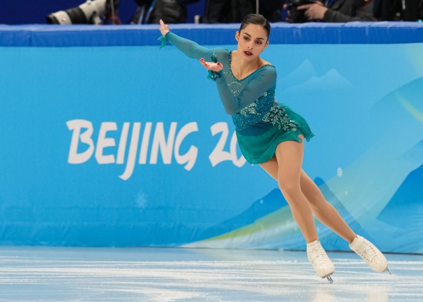 La Canadadienne Madeline Schizas écarte le bras droit sur le côté droit de son corps et le bras gauche devant elle lors d'une épreuve de patinage artistique à Beijing 2022.