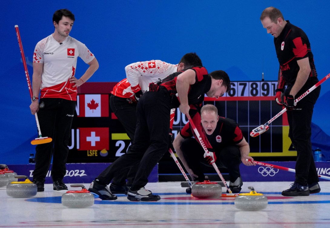 Mark Nichols sur la surface de curling, ses coéquipiers autour et les adversaire de la Suisse à gauche.  