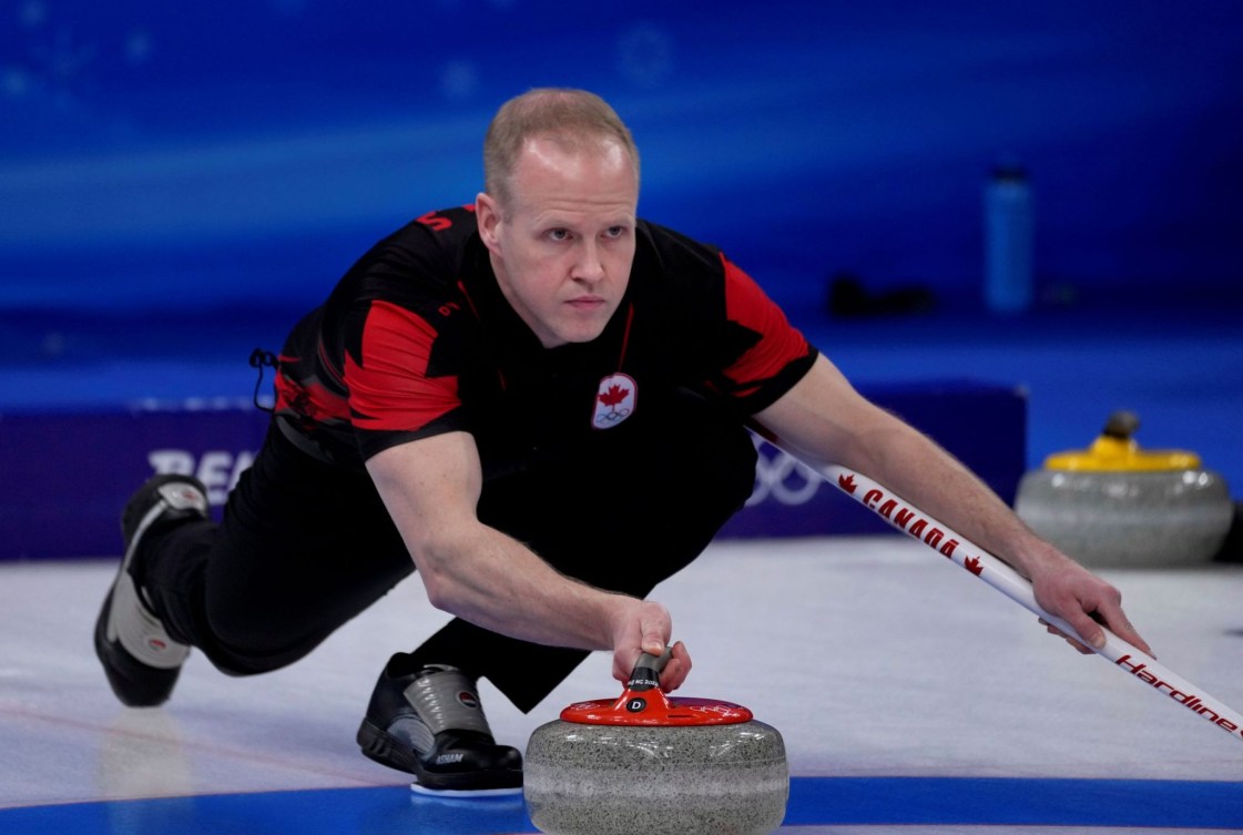 Le curleur canadien Mark Nichols regarde droit devant alors qu'il lance une pierre dans un match de curling masculin à Beijing 2022.