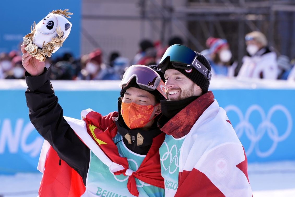 Max Parrot et Yiming Su de l'équipe de Chine s'entrelacent par les épaulent pour célébrer leurs performances au big air en snowboard à Beijing 2022