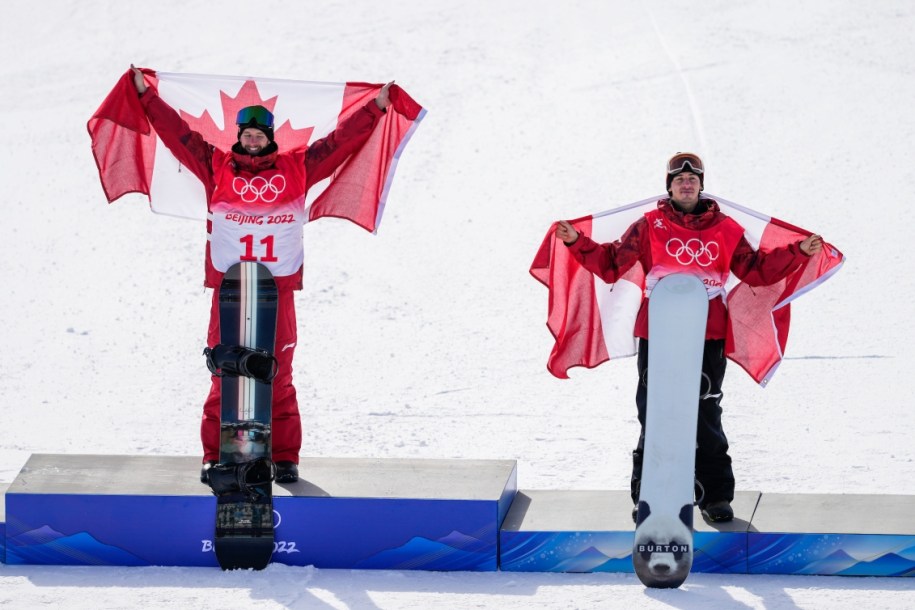 Les planchistes canadiens Max Parrot et Mark McMorris sur le podium du slopestyle masculin àa Beijing 2022. Les deux Canadiens sont drapés du drapeau canadien.