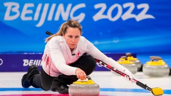 La curleuse canadienne Rachel Homan laisse partir une pierre durant un match de curling à Beijing 2022.