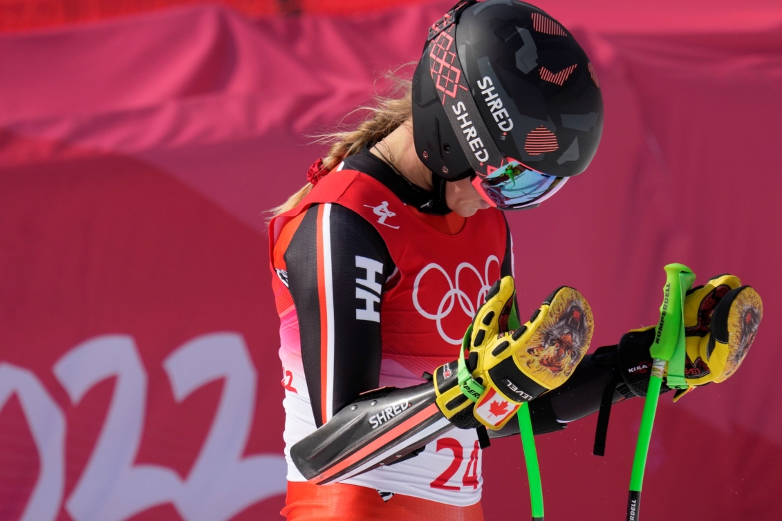 Une skieuse sourit avec ses bâtons dans les mains. 