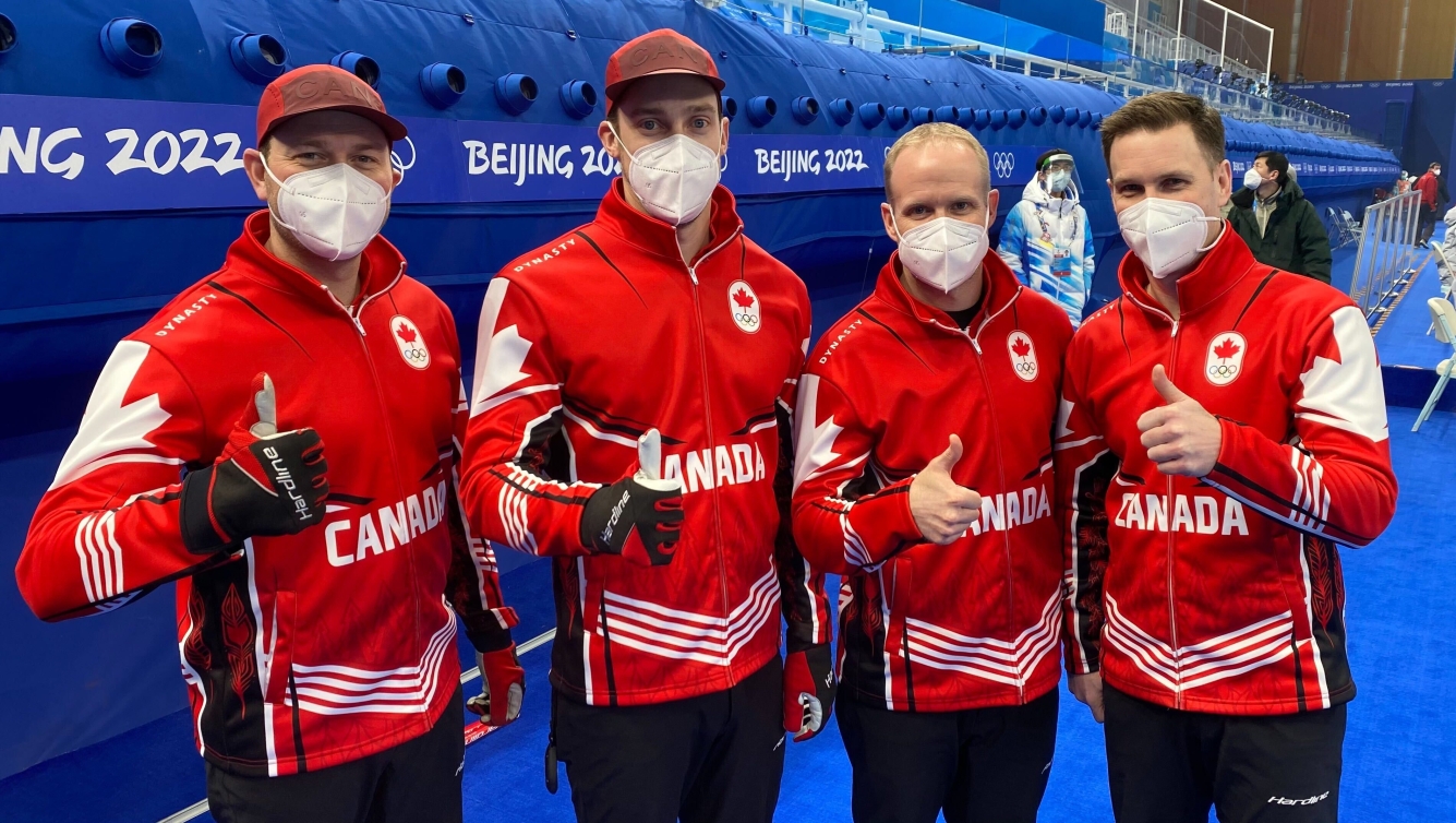 Équipe Gushue pose devant la caméra avec le pouce en l'air. 