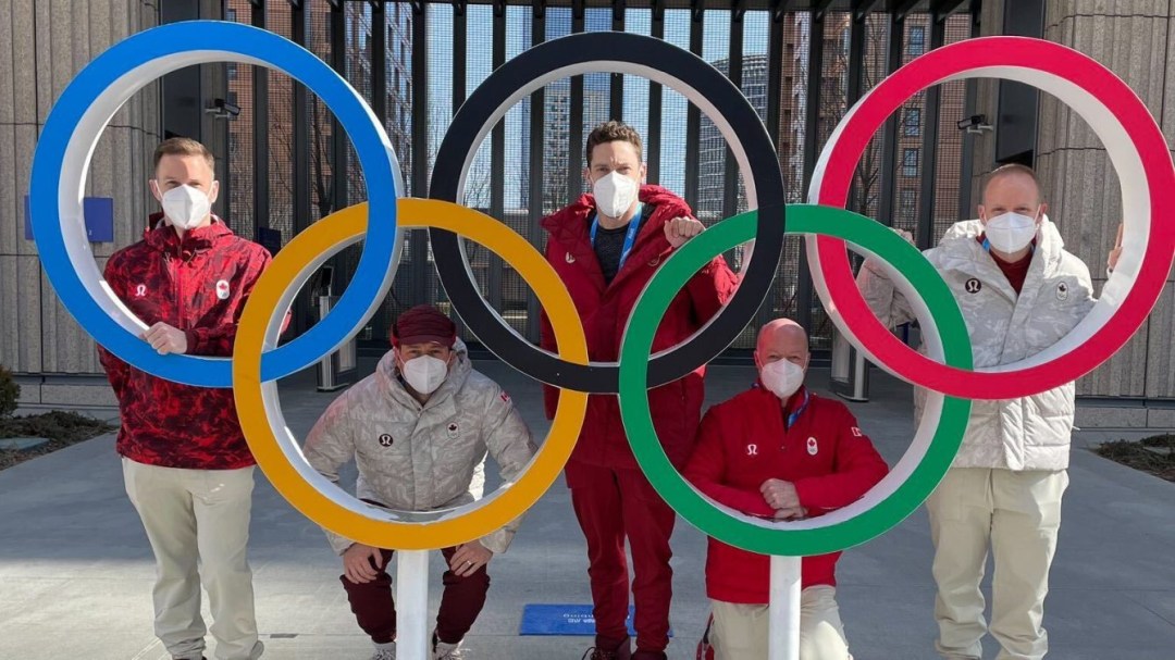 Les membres d'Équipe Gushue pose à l'intérieur des anneaux olympiques à Beijing 2022.