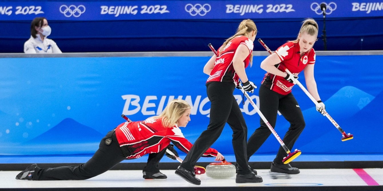 Jennifer Jones lance une pierre tandis que ses coéquipières se préparent à balayer la glace à ses côtés lors du match contre la Corée à Beijing 2022