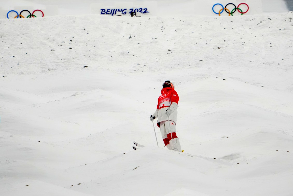 Justine Dufour-Lapointe, debout au milieu de la piste de bosses, regarde au ciel.