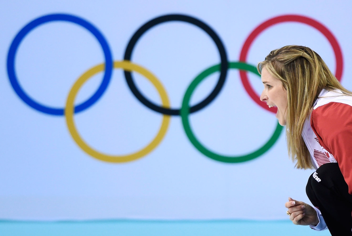 Jennifer Jones accroupie de côté devant les anneaux olympiques.