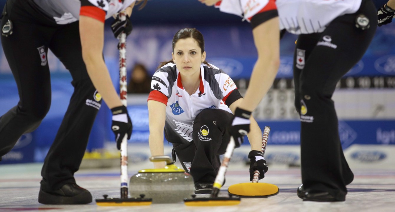 Lisa Weagle, au centre, regarde alors que ses coéquipières Emma Miskew, à gauche, et Joanne Courtney balayent le trajet de la pierre.