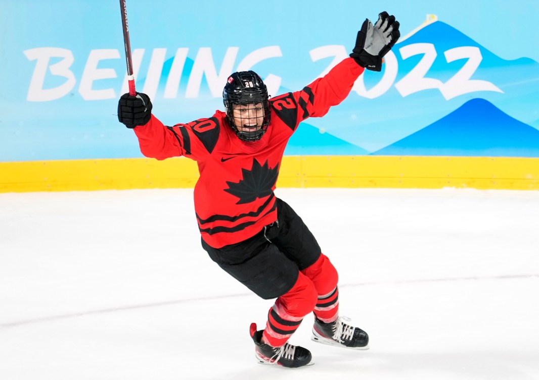 Sarah Nurse lève un gant et son bâton de l'autre main dans les airs pour célébrer son but lors du match de la finale contre les États-Unis à Beijing 2022