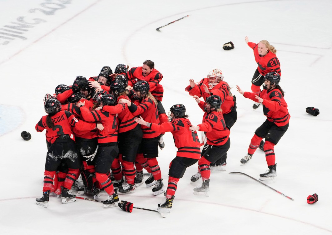 Les membre de l'équipe féminine de hockey sur glace s'enlacent avec fougue après avoir gagné l'or à Beijing 2022.