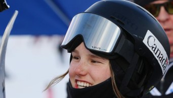 Megan Oldham portant son casque de ski et ses lunettes fait un sourire