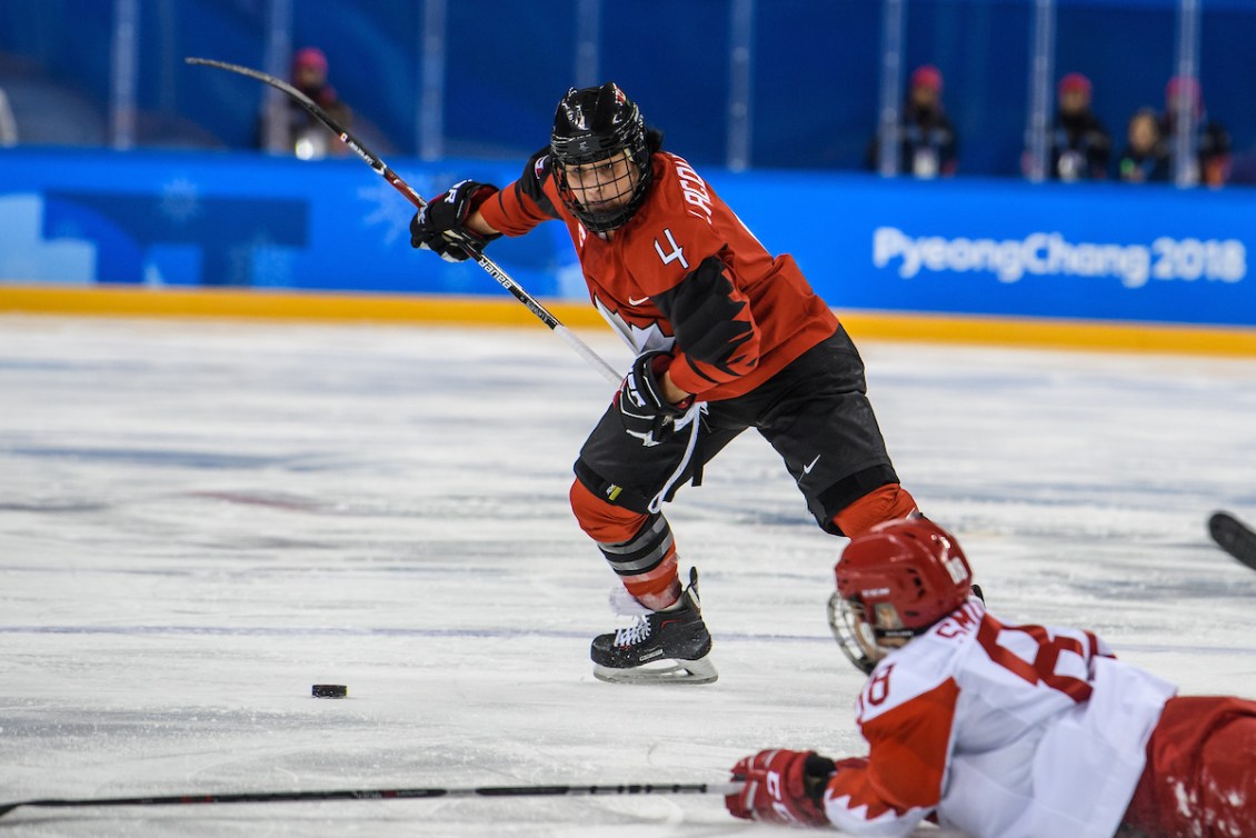 Brigette Lacquette élance son bâton dans les airs et s'apprête à tirer contre la gardienne de l'équipe du Comité olympique russe lors des rondes préliminaires de PyeongChang 2018.