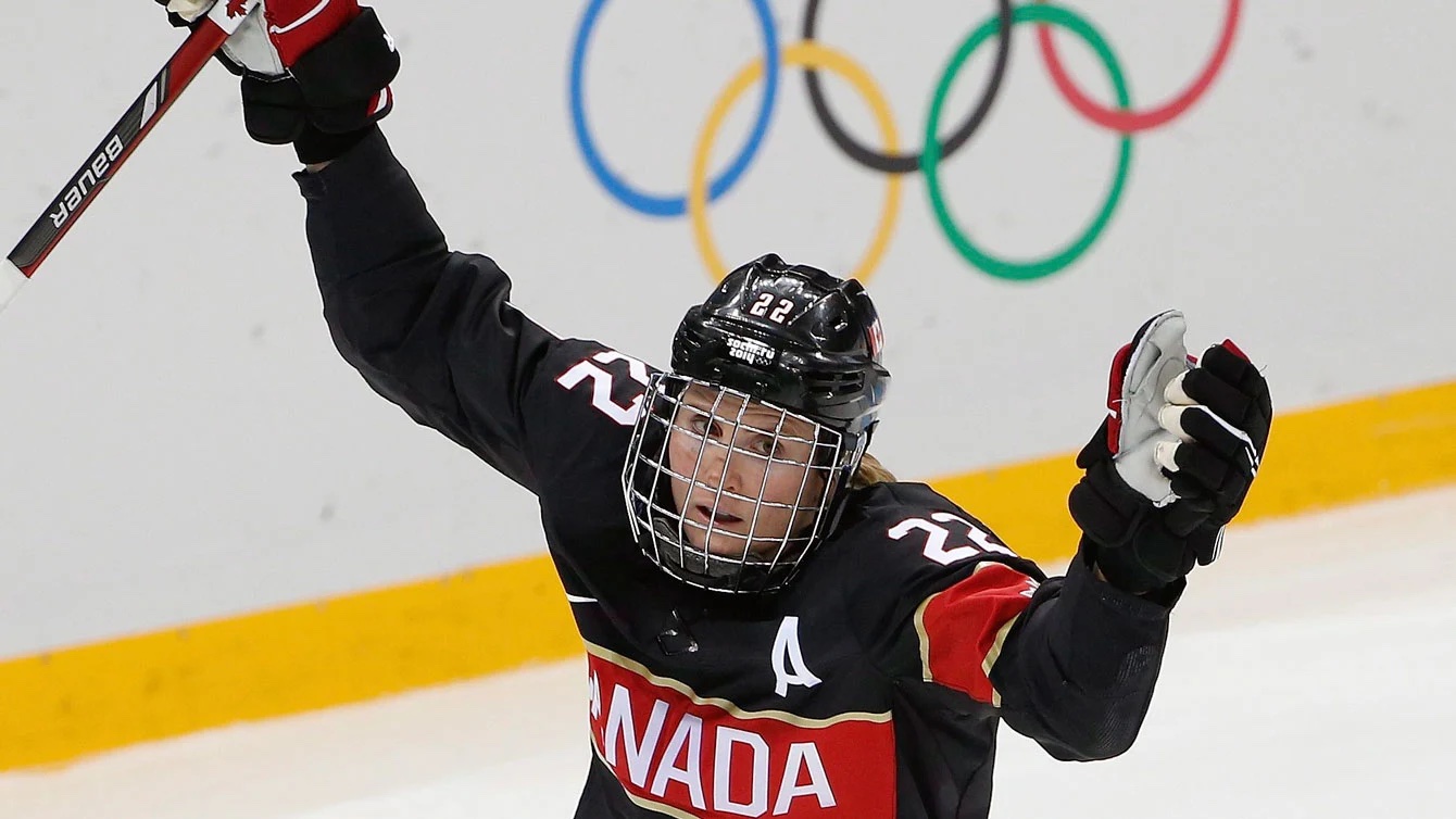 Une hockeyeuse lève les bras dans les airs. 