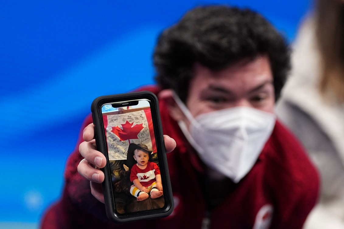 Keegan tient un téléphone avec la photo de son fils sur l'écran.
