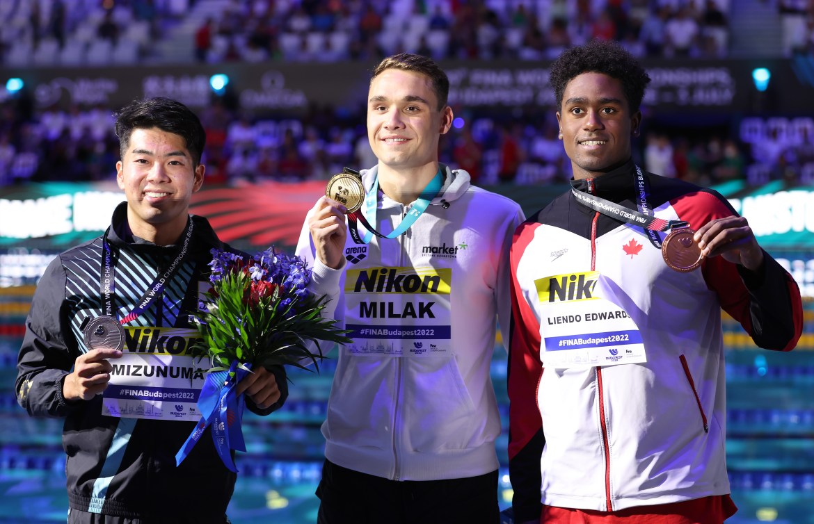 Trois athlètes avec leur médaille. 