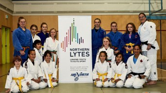 De jeunes judokas devant l'affiche du programme Northern Lytes