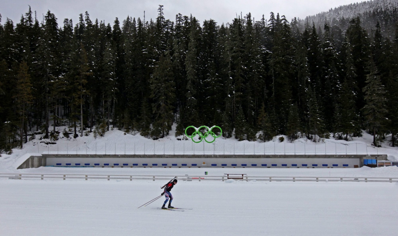 Le biathlète à la retraite Colin Bell, de Canmore en Alberta, ski devant le stand de tir pendant une démonstration au Parc olympique de Whistler.