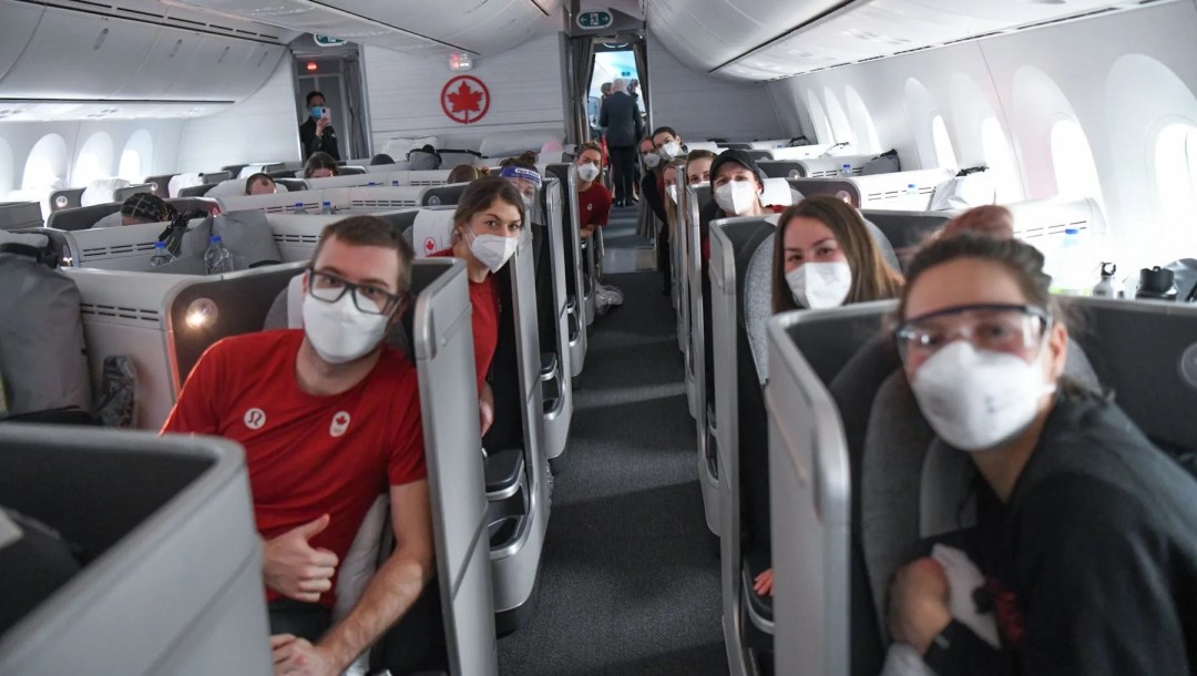 Des athlètes à bord d'un avion.