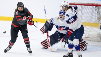 Une joueuse de hockey canadienne tir dans le but de l'équipe américaine.