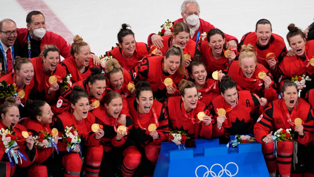Les joueuses de hockey canadiennes célèbrent leur médaille d'or sur la glace.