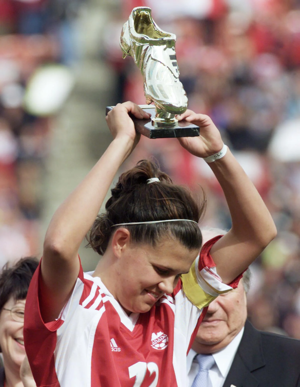 Christine Sinclair tient un trophée doré.