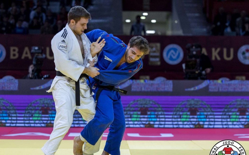 Arthur Margelidon en blanc fait face à son adversaire en bleu sur le tapis de judo