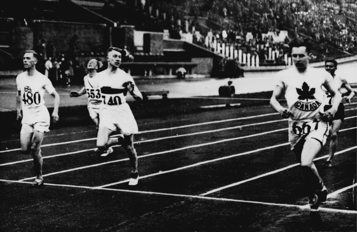 Des hommes sur la piste d'athlétisme. Photo en noir et blanc.
