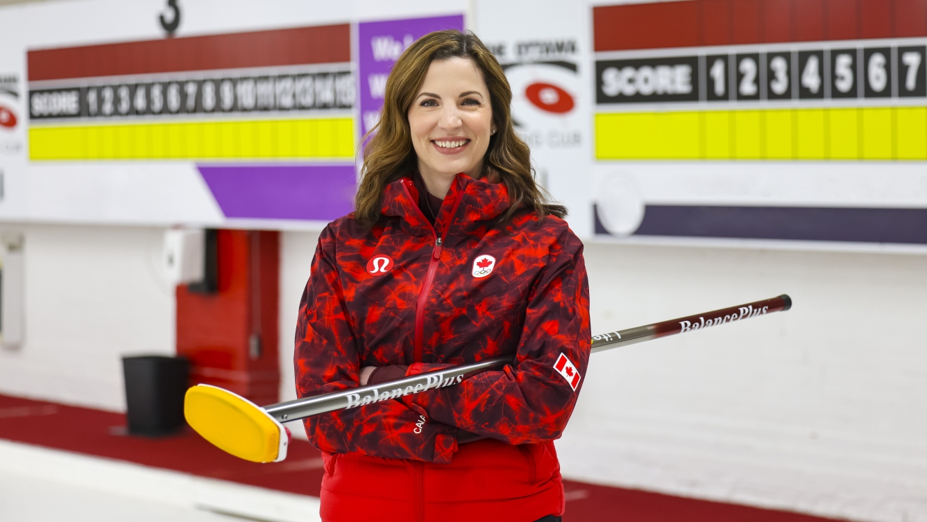 Lisa Weagle pose avec un balai de curling dans les mains.