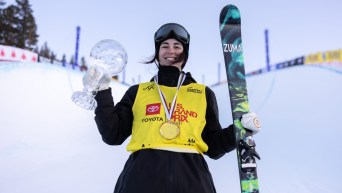 Rachael Karker tient ses skis et un globe de cristal.