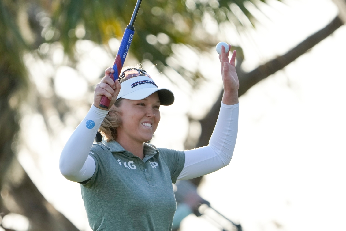 Brooke Henderson lève les bras dans les airs. 