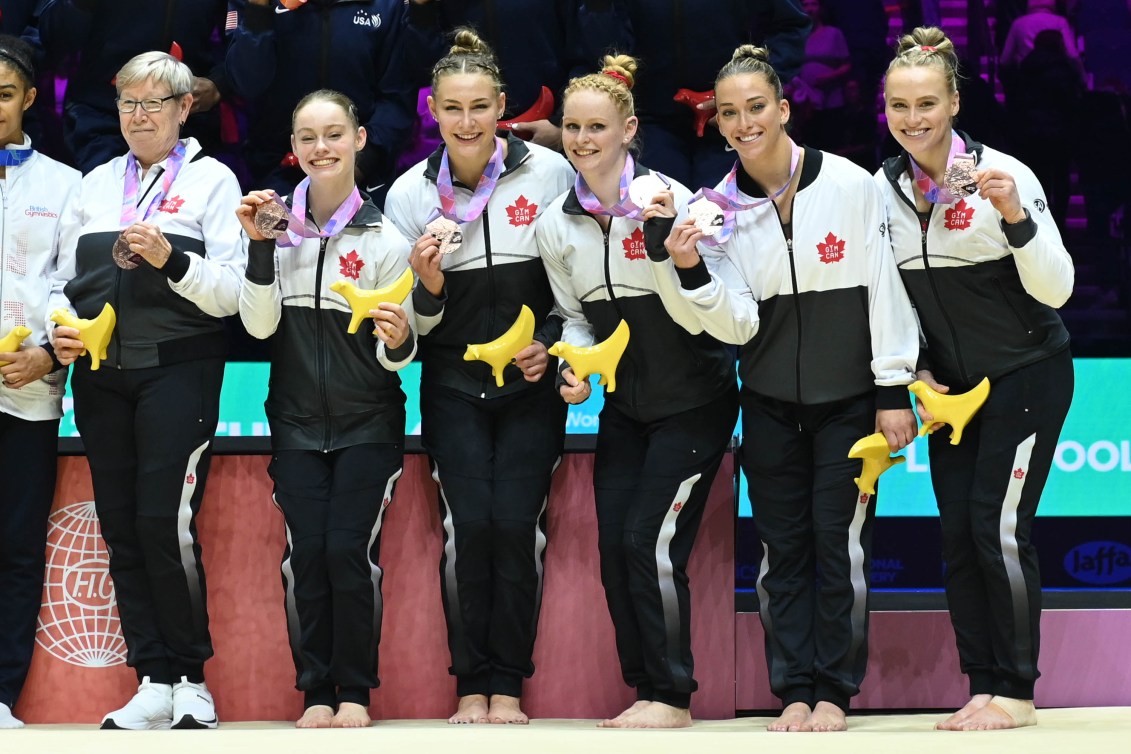 Les gymnastes canadiennes montrent leur médaille de bronze. 