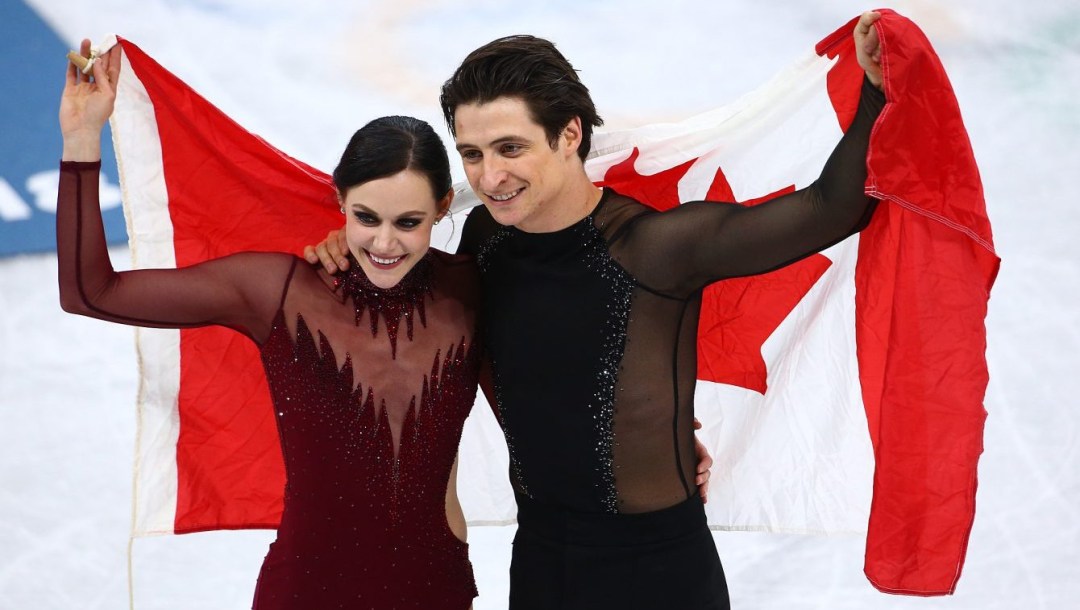 Scott Moir et Tessa Virtue font un tour de glace avec le drapeau canadien