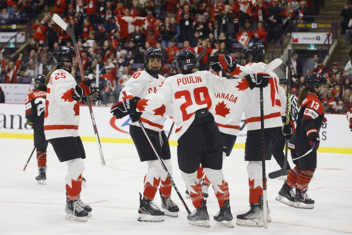 Les joueuses d'Équipe Canada célèbrent sur la glace. 