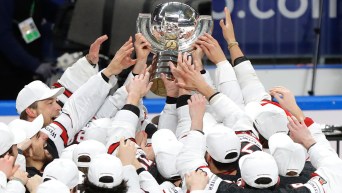 Des joueurs de hockey soulèvent un trophée.