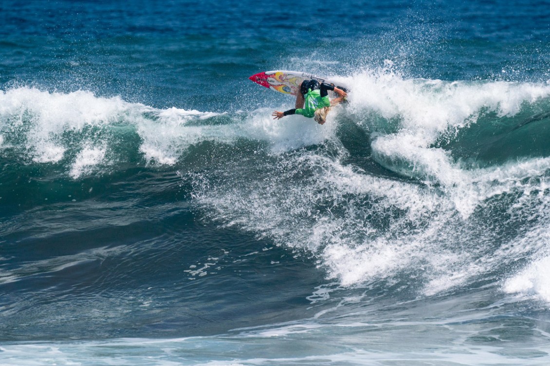 Erin Brooks est presque à l'envers en surfant sur une vague sur sa planche de surf
