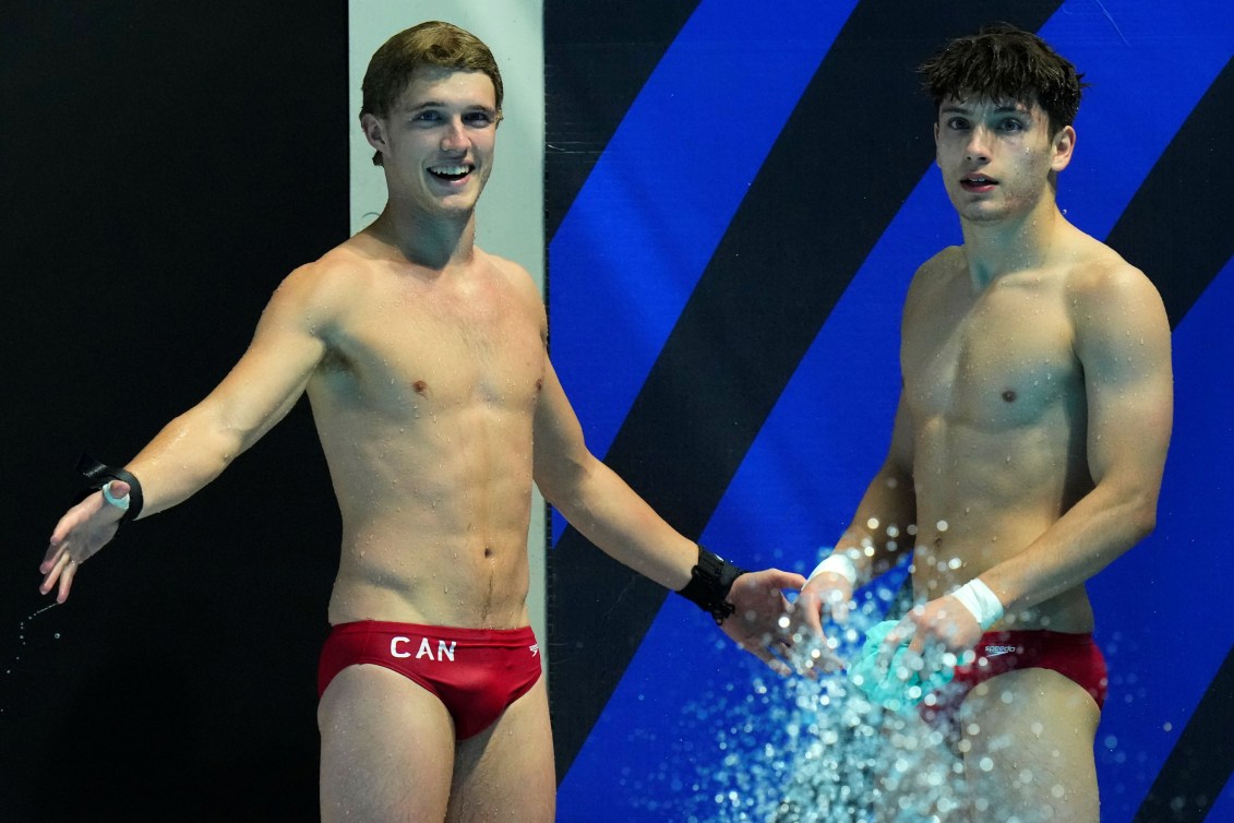 Rylan Wiens et Nathan Zsombor-Murray debout sur le bord de la piscine.